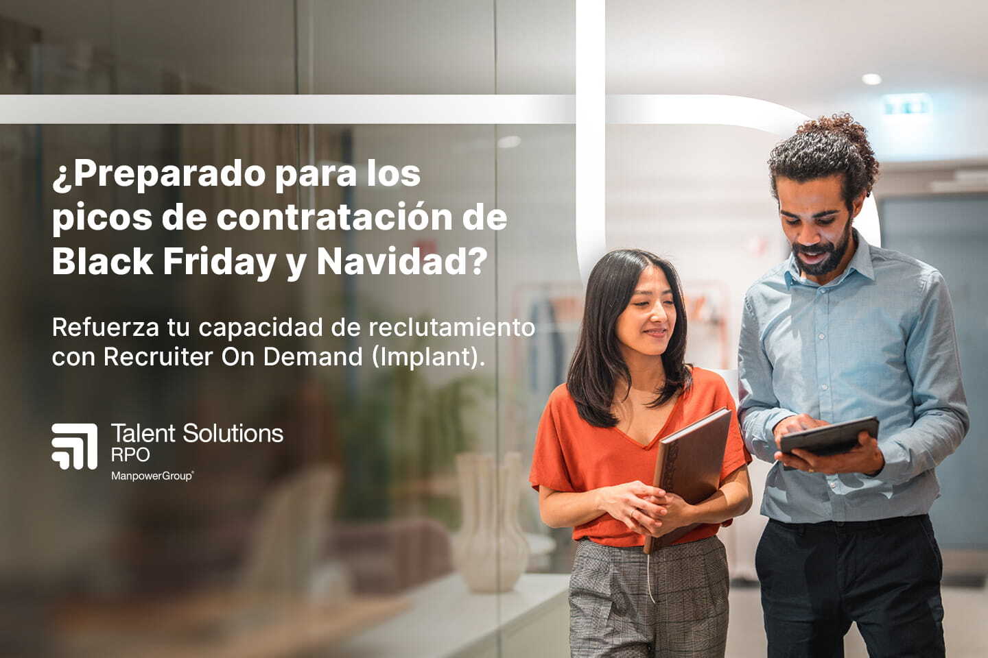 Dos compañeros de trabajo en una oficina con fondo corporativo de Talent Solutions