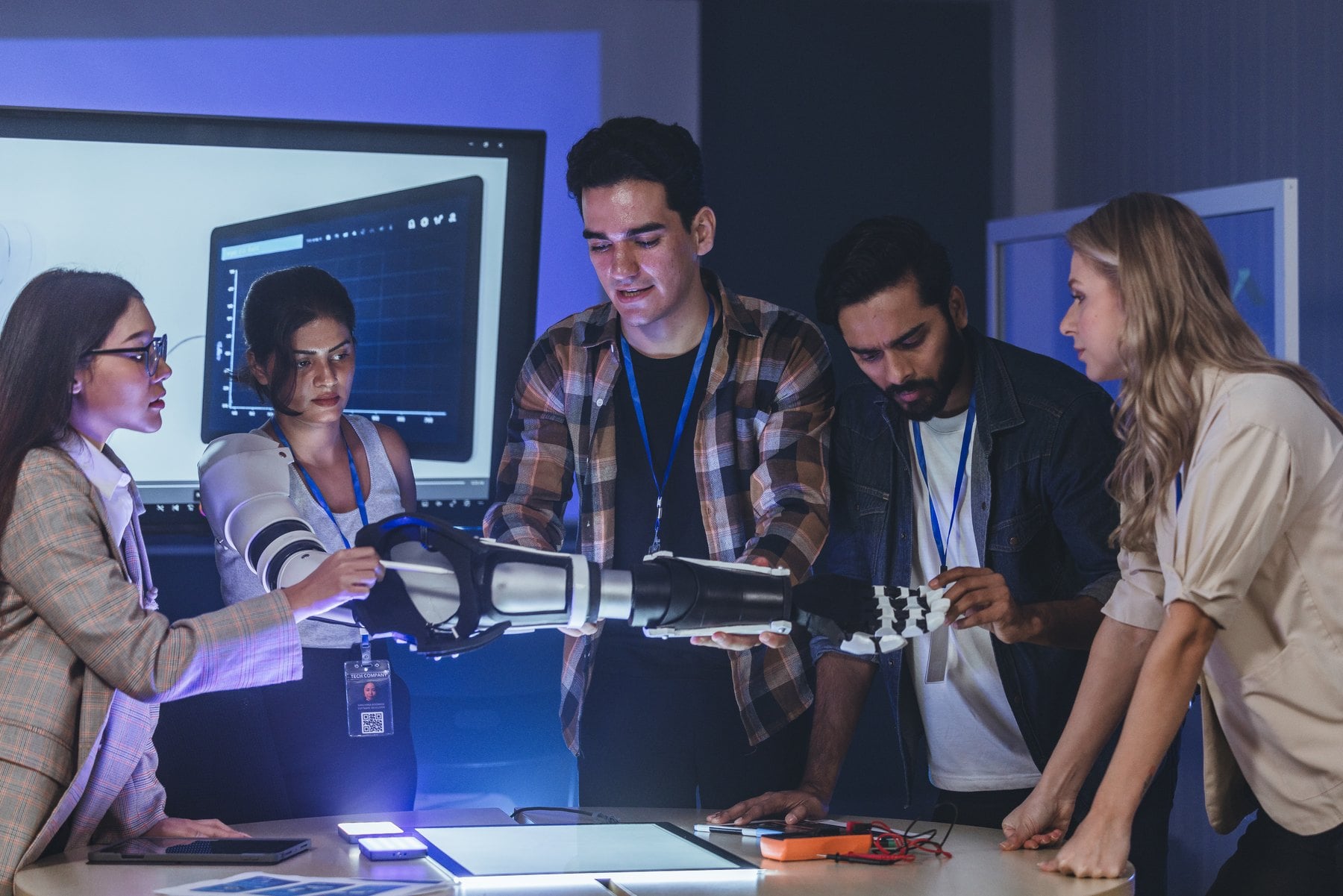 Jóvenes profesionales colaboran con un brazo robótico durante una formación en competencias tecnológicas