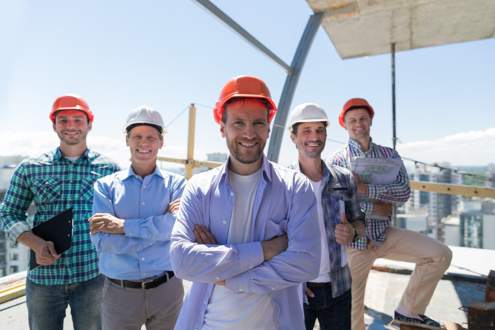 Equipo de construcción sonriendo en una obra sin gafas de sol