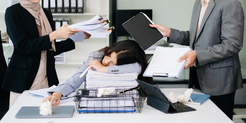 Mujer agotada laboralmente en una oficina