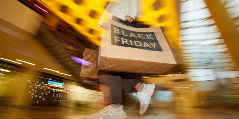 Persona caminando con una bolsa de compra de Black Friday en un centro comercial