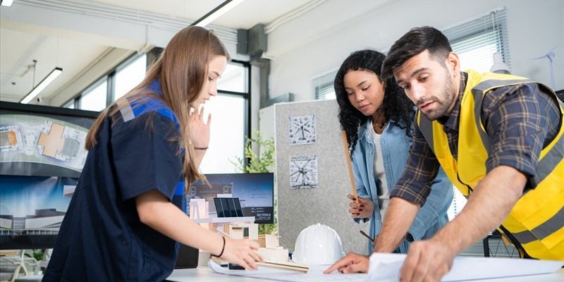Equipo técnico colaborando sobre planos en un entorno profesional