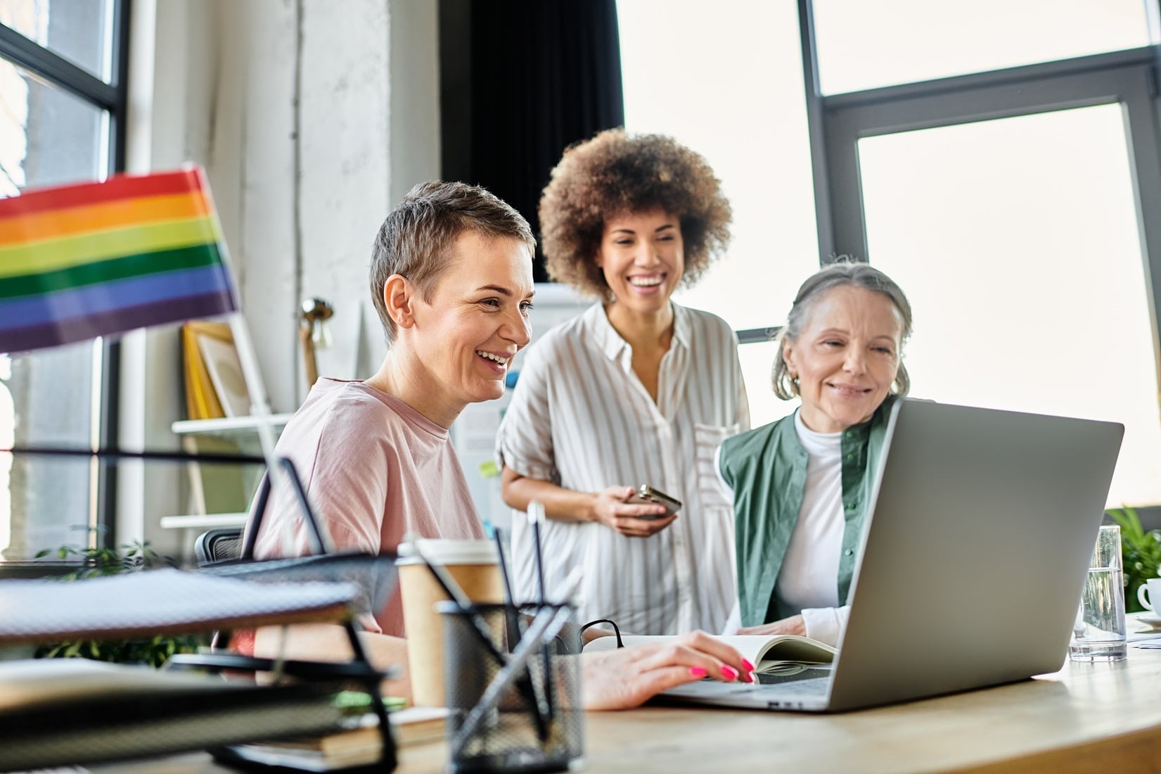 Mujeres trabajando en una oficina con bandera LGTBIQ+