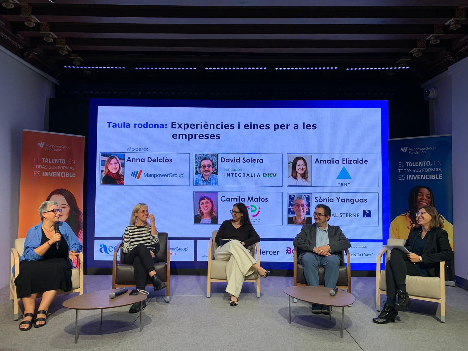 Ponentes del evento sentados y hablando al público