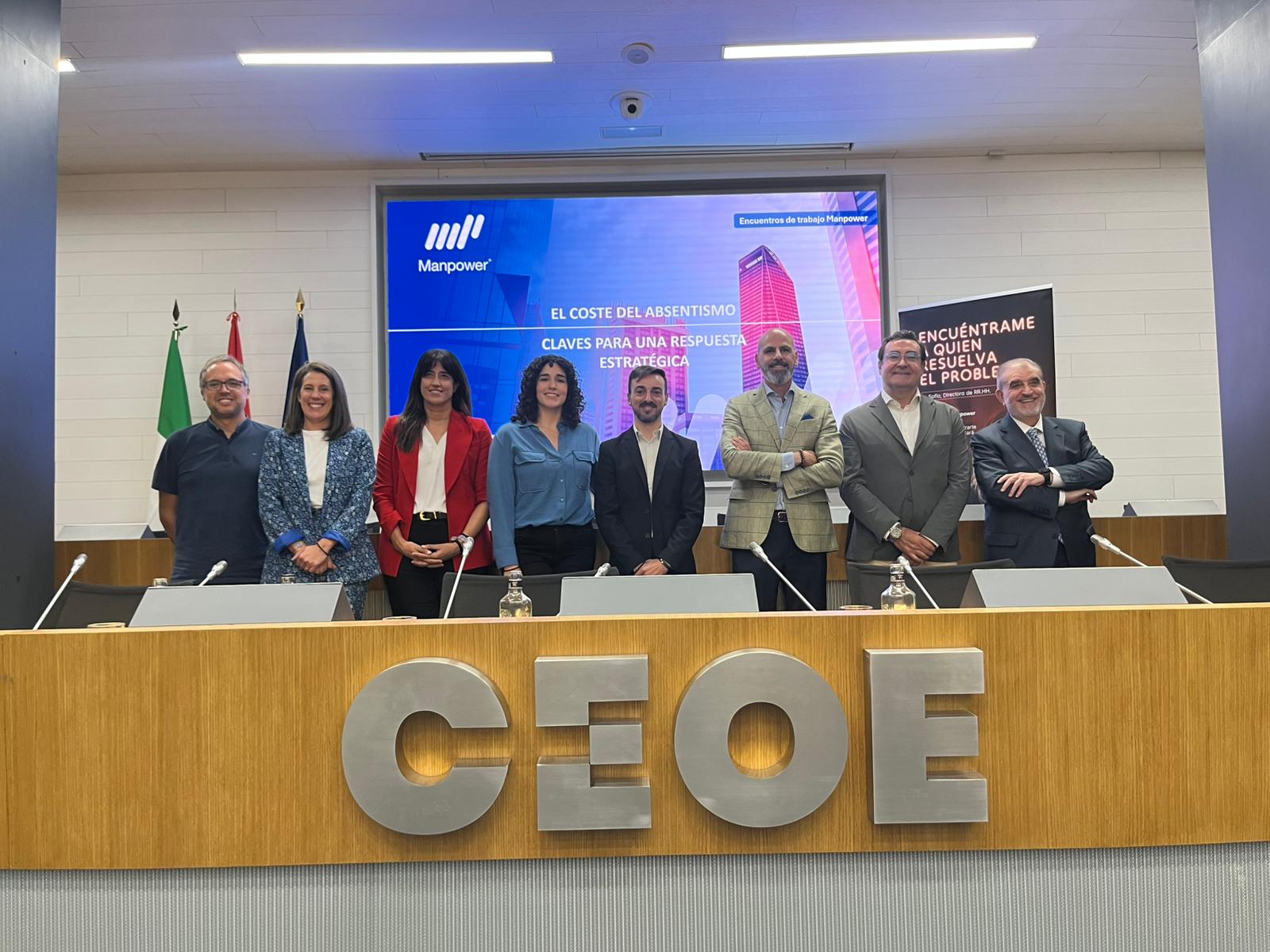 Hombres y mujeres de Manpower y CEOE posando en la sala de eventos.