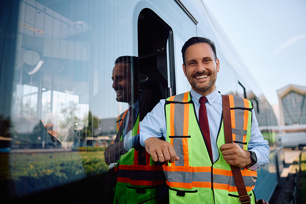 conductor de autobús sonriente con chaleco de seguridad
