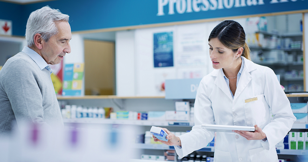 Farmacéutica aconsejando a un cliente de avanzada edad