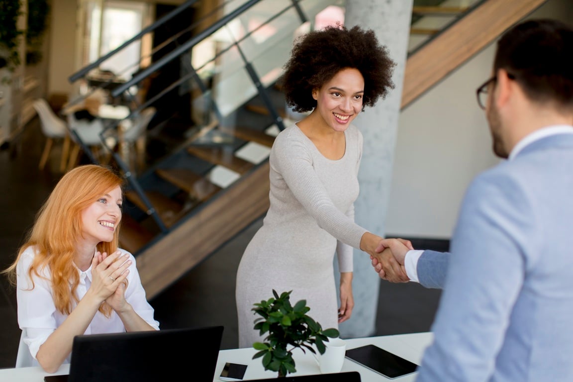 Mujer estrechando la mano con un hombre